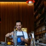 man holding blue mug
